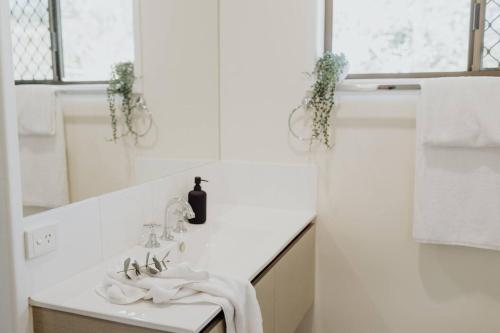 a white bathroom with a sink and a mirror at Acreage property, pet friendly, outdoor campfire in Bald Knob
