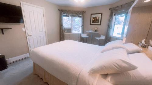 una camera da letto con un grande letto bianco e un tavolo di Cornerstone Bed and Breakfast a Revelstoke