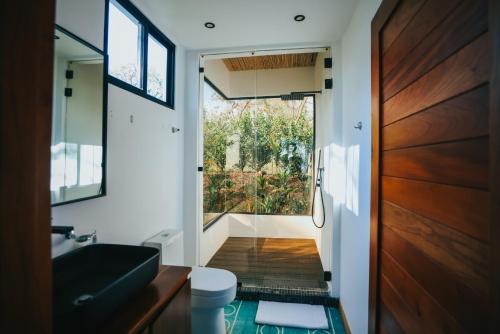 a bathroom with a large window and a door at Hotel Bohemian Lagarto in Santa Cruz