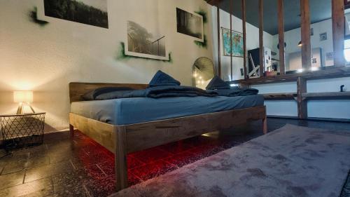 a bedroom with a bed with blue sheets on it at Das Atelier - Kunstvoll verweilen in Ichtershausen
