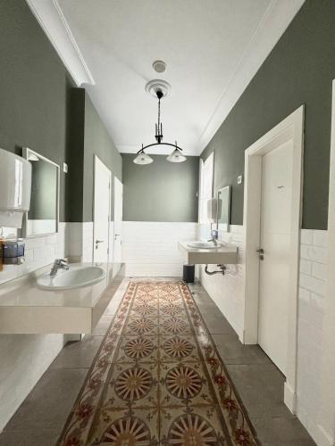 a large bathroom with two sinks and two mirrors at Albergue Gran Canaria in Las Palmas de Gran Canaria