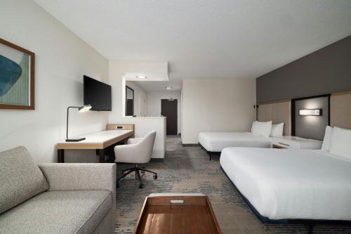 a hotel room with two beds a couch and a desk at SpringHill Suites Boca Raton in Boca Raton