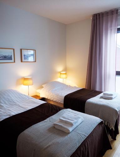 a hotel room with two beds and a window at Hotel Korpoström in Korpoström