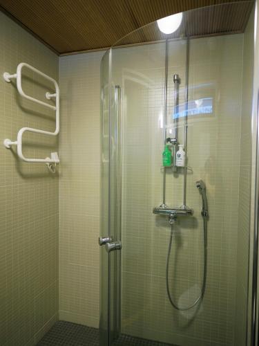 a shower in a bathroom with a glass shower stall at Hotel Korpoström in Korpoström