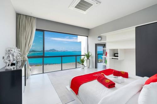 a bedroom with a large white bed with red pillows at STK Villa Samui Paradise Awaits in Nathon Bay