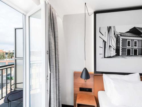 a bedroom with a bed and a balcony at Mercure Klaipėda City Hotel, Meetings, Events, Restaurant & Bar - Accor Group in Klaipėda