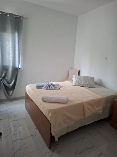 een bed met twee handdoeken erop in een slaapkamer bij Casa do Céu Azul in Tarrafal