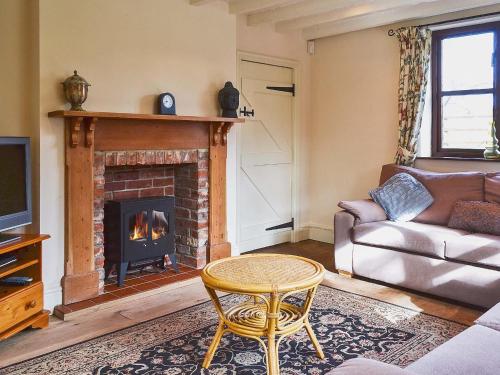 a living room with a couch and a fireplace at Bridge House in Overseal