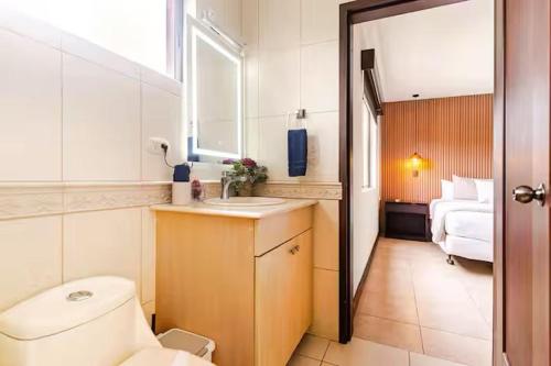 a bathroom with a toilet and a sink and a bed at Palmas de Tamarindo Resort, 304E in Guanacaste