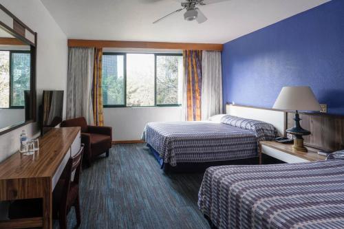 a hotel room with two beds and a television at Hotel New York Ciudad de Mexico in Mexico City