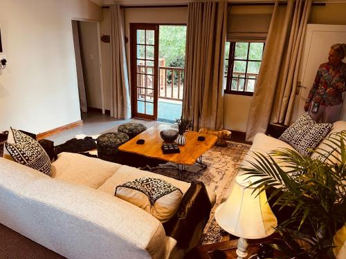 a living room with a couch and a table at Haze Inn Cottages Crowned in Henburg Park