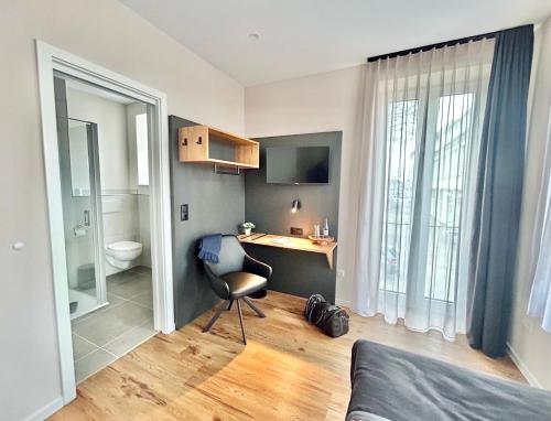 a bedroom with a desk and a toilet in a room at City Pension Heide in Heide