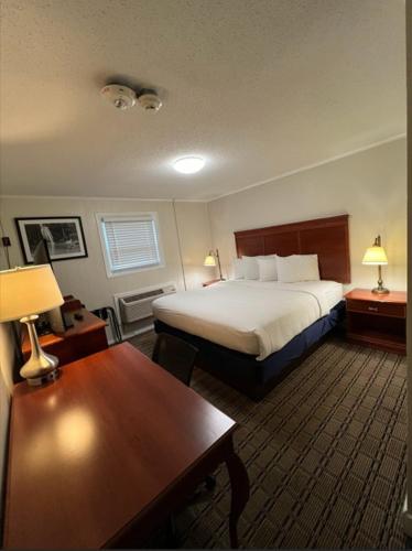 a hotel room with a bed and a table at River Valley Inn in Hatfield
