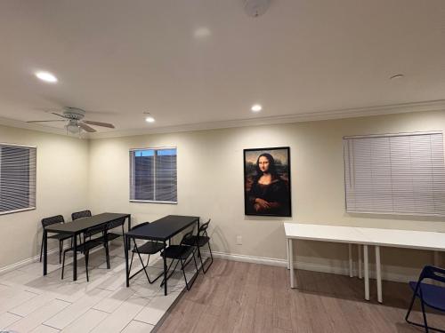a dining room with two tables and a painting on the wall at Blue Urban Stay LA in Los Angeles
