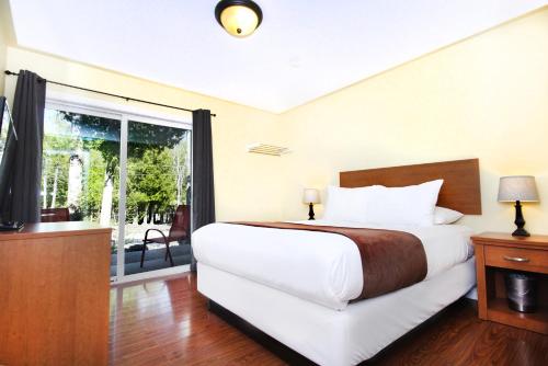 a bedroom with a large bed and a large window at Escarpment Heights Motel in Tobermory