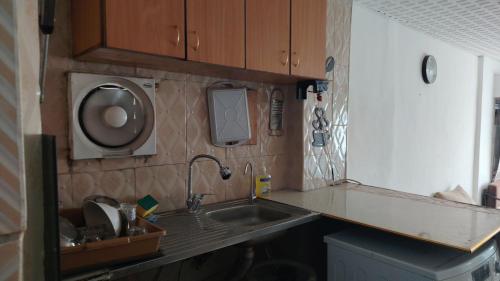 a small kitchen with a sink and a microwave at بيت الحجر 2 in Amman