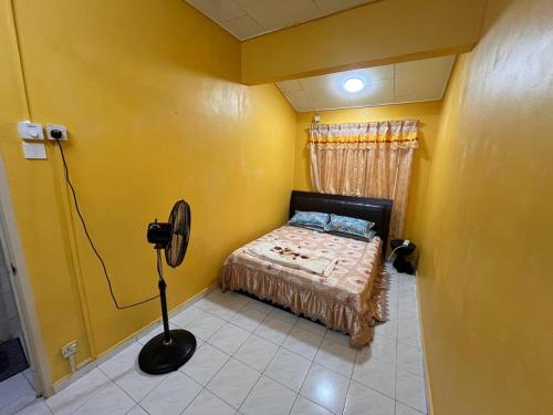 a bedroom with a bed in a yellow room at Teratak Embah in Nilai