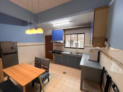 a kitchen with a wooden table and a table and a dining room at Teratak Embah in Nilai