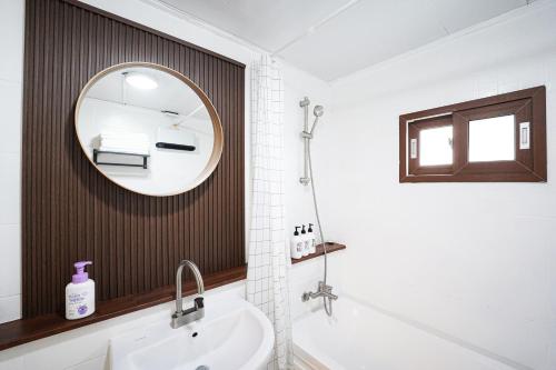 a bathroom with a sink and a mirror at Traditional Korean houses Stay Yeon in Busan