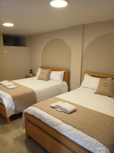 two beds in a small room with twoermottermott at Hostal Tayupanda in Quito