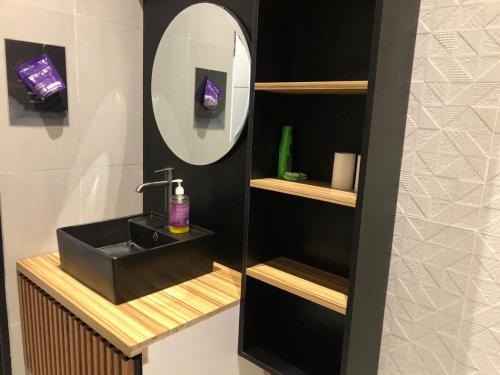 a bathroom with a black sink and a mirror at Light Star Villa in Kuta Lombok