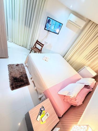 a hotel room with a bed and a television at Vila do Morro Pousada in Morro de São Paulo