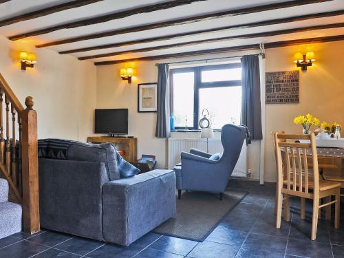 a living room with a couch and a chair and a table at Granary Barn in Marros