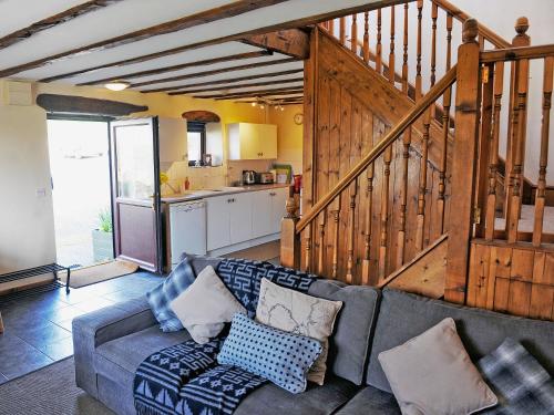 a living room with a couch and a kitchen at Granary Barn in Marros