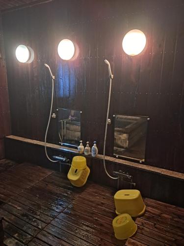 a bathroom with a yellow toilet and a mirror at 宿小町や in Senboku