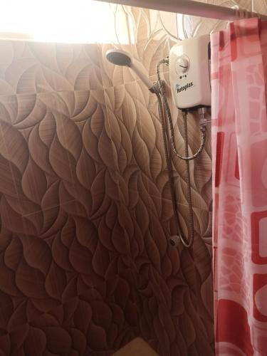 a shower with a hair dryer on the wall at Hostal Mitopampa in Lambayeque