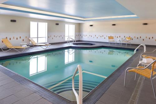 a pool in a hotel room with chairs and a pool at Fairfield Inn & Suites by Marriott Barrie in Barrie