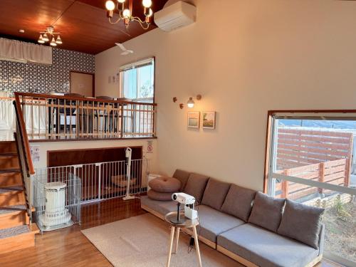 a living room with a couch and a staircase at 羽咲亭乃台 in Kannami