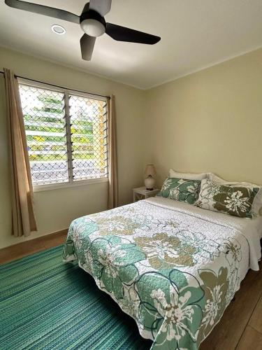 Un dormitorio con una cama y un ventilador de techo. en Beach House - Maninoa, en Maninoa