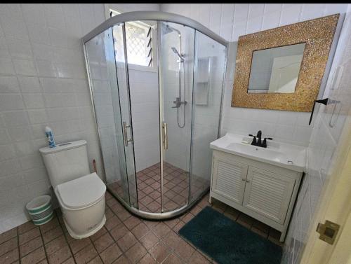 Un baño con ducha, inodoro y lavabo. en Beach House - Maninoa, en Maninoa