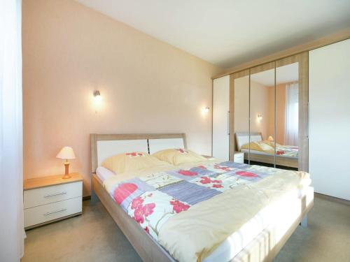 a bedroom with a large bed and a mirror at Ferienwohnung in der Vulkaneifel in Winkel