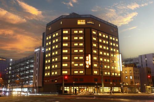 a tall building with lights on in a city at Natural Hot Spring Echizen no Yu Onyado Nono Fukui in Fukui