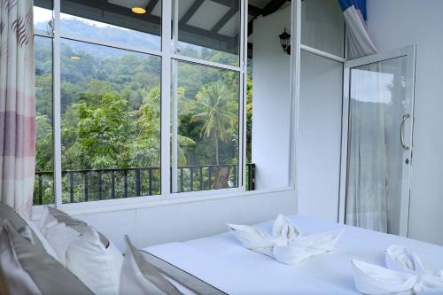 a dining room with a window and a white table and chairs at HILL SIDE RESORT - Ella in Ella
