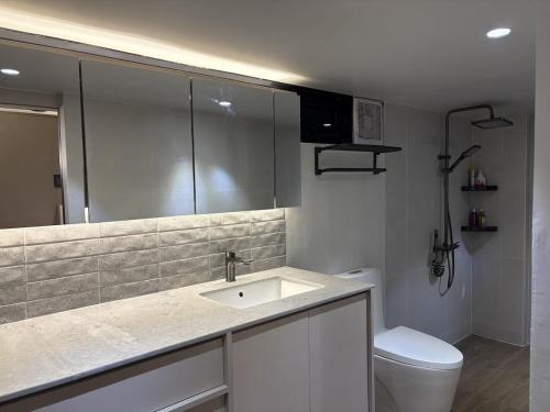 a bathroom with a sink and a toilet at Elev Ph - Staycation Penthouse in San Nicolas