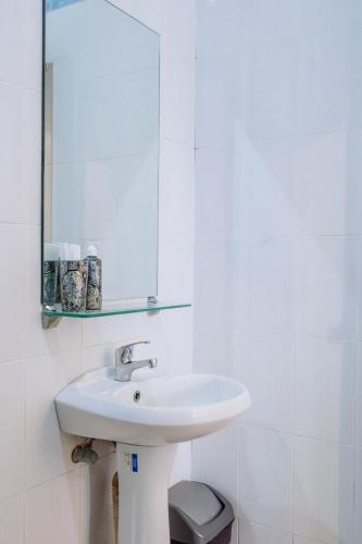 a white bathroom with a sink and a mirror at MIMU C-O Living in Kerobokan