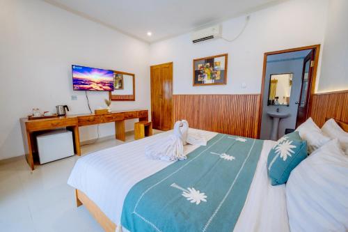 a bedroom with a bed and a desk in it at MIMU C-O Living in Kerobokan