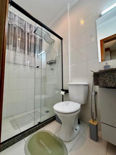 a bathroom with a toilet and a glass shower at Apê Moderno in Caxambu