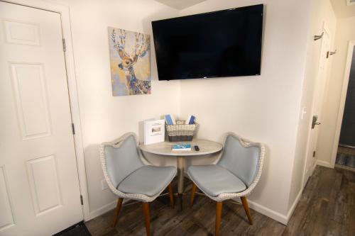a room with a table and two chairs and a flat screen tv at Creature Comforts Suite-Private Hot Tub-Sleeps 2 in Ahwahnee
