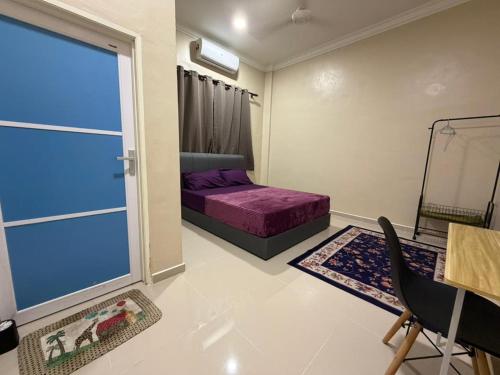 a bedroom with a purple bed and a window at Teratak Bonda in Temuh