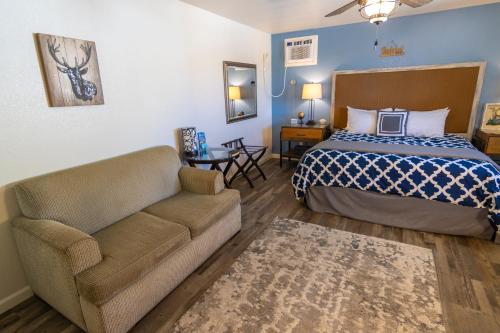 a hotel room with a bed and a couch at Creature Comforts Suite-Private Hot Tub-Sleeps 2 in Ahwahnee