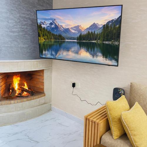 a living room with a fireplace and a tv on the wall at Prime stay downtown Meknes in Meknès