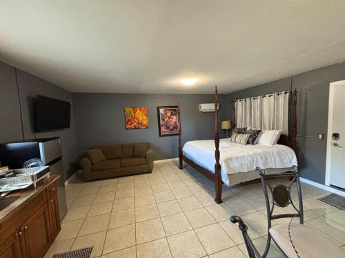 a bedroom with a bed and a couch and a television at Beach getaway - Private paradise - Clearwater in Clearwater