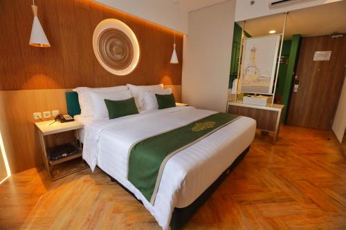 a bedroom with a large bed with a wooden headboard at Patra Malioboro Hotel in Yogyakarta