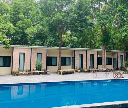 a resort with a swimming pool and trees at สวนธรรมคยา in Ban Dan Chang
