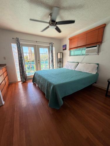 a bedroom with a bed and a ceiling fan at Surfers Dream Studio in Waianae
