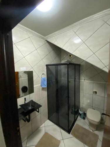 a bathroom with a toilet and a glass shower at Hostel Anprado #12 Kit café incluso, Próx-Aeroporto de Guarulhos in Guarulhos